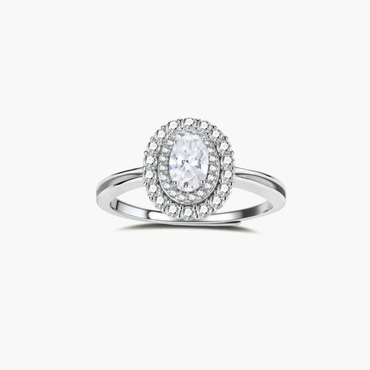 Sterling silver ring with oval moissanite center stone surrounded by double halo of sparkling stones on neutral background.