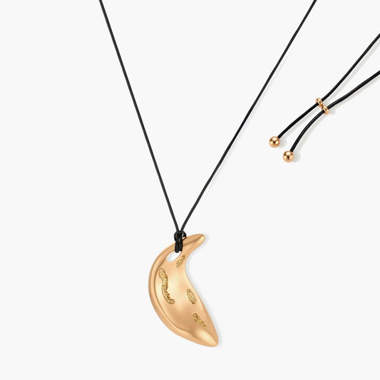 Gold crescent moon pendant with paisley patterns on adjustable black cord with brass beads